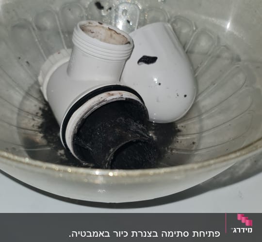 חלקי צנרת מלוכלכים בקערה שקופה
